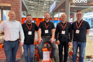 Team Liftroller standing in fron of the Liftroller stand at BAUMA 2025, in Munich