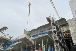Crane lowering construction materials onto a Liftroller Floor at a new build project..
