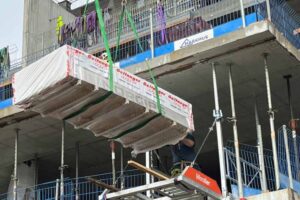 Crane lowering construction materials onto a Liftroller Floor at a new build project..