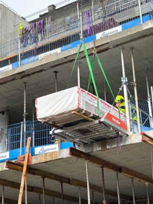 Belevue_Nybyggna_Byggmester Markhus_Liftroller Floor Paket med gipsskivor rullas in i byggnaden med Liftroller Floor